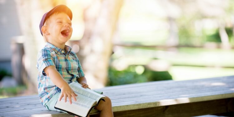 boy sitting on bench while holding a book